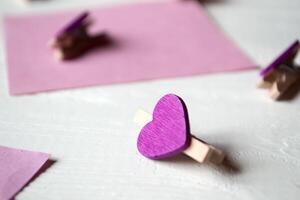Decorative pins and pink memo sheets on a white wooden background. photo