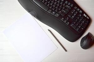 Black keyboard, mouse white pencil and pen on the white table. photo