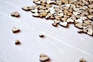 Decorative wooden hearts on a white desk. Love background. photo