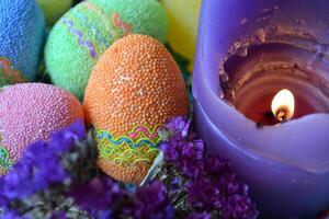 Colorful easter eggs with flowers and candles in the plate. Beautiful easter background. Easter card. Homemade holiday decor. photo