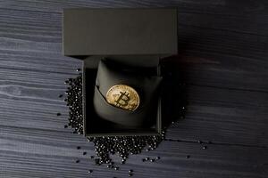 dorado bitcoin en un negro caja. oro moneda de criptomoneda foto