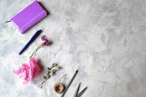 Notebook, pen,pencil,flower, eucalyptus, scissors on the textured table. Background with objects for workshop and place for text. photo