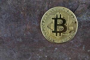 Golden bitcoin on stone background. photo