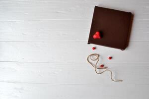 regalo caja con rojo corazón en un blanco de madera antecedentes. foto