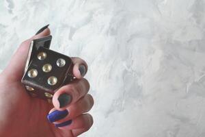 Dice cube with precious jewels female hand. Woman holding plaing cube. photo