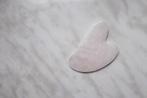 raspador gua sha, Rosa cuarzo. piel cuidado dispositivo. foto