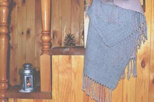 Cozy home. Scarf, cone and candle lantern on the wooden stairs. photo