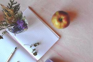 Opened notebook and pen on the pink concrete table. Beautiful business flat lay. photo