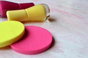 Creative beauty background. Nail polishes and sponges in trendy colors. photo