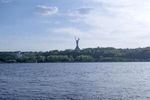 ver desde el izquierda banco de Kiev con patria Monumento. Kiev paisaje urbano, Ucrania foto