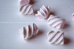 Pink marshmallow on a white wooden table. photo