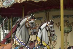 Vintage european carousel in a park. Merry go round horses. Retro style carousel. photo
