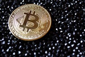 Golden bitcoin on a black jewels. Gold coin of cryptocurrency. photo
