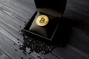 dorado bitcoin en un negro caja. oro moneda de criptomoneda foto