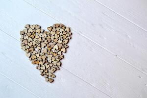 Decorative wooden hearts in a form of heart on a white desk. Love background. photo