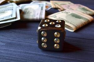 Dice cube with precious jewels on the table and money. Plaing cube. Games of chance. photo