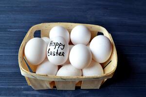 Eggs in a basket on the wooden vintage table. Happy Easter Day. Easter backgrund. photo