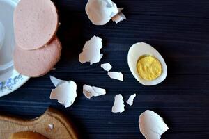 Sliced eggs, eggs shell on a wooden board. Macro food photography. Homemade food still life. photo