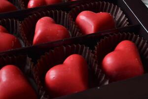 The box of red candies in a form of heart. photo
