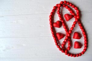 Red candies on the white wooden table. Background for greeting card on Valentine's day with place for text. photo