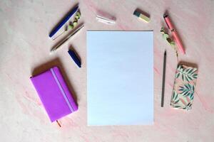 White sheet of paper, pens, pencil, nonebook on the desk. Workspace for art. Place for painting. photo