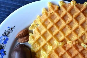 gofres en el plato con pastel y nueces. sabroso desayuno antecedentes. foto