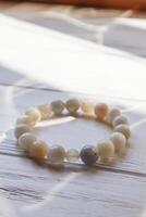 Bracelet from moonstone on a white table. photo