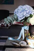 Bouquet of blue hydrangea and eucalyptus branches in vase, at living room. photo