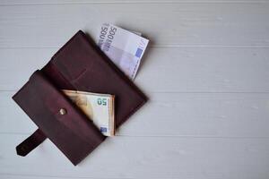 Euro money banknotes and wallet on the white wooden desk. Business money background. photo