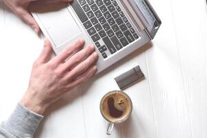 Man working at a laptop, additional business form background, mobile phone laptop operation business photo