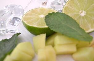 Apple, mint and lime on a white table. Ingredients for healthy lemnade. photo