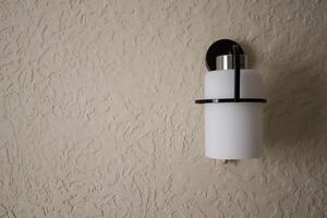 Sconce on beige textured wall. photo