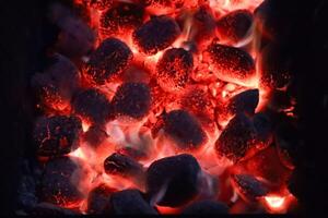 ardiente carbones en el parrilla, cerca arriba. foto