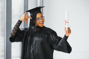 contento africano americano hembra estudiante con diploma a graduación foto