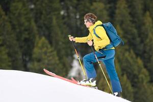 un hombre va arriba montaña esquís foto