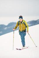solo hombre va arriba en esquís con pieles de foca foto