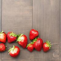 AI generated eap of fresh strawberries in bowl on white wooden background. Top view point. photo