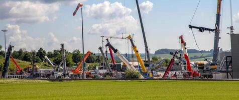 Panoramic view of many different truck cranes in the parking yard photo