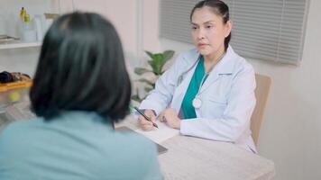 fêmea médico explica prescrição para doente cliente. médico dá consulta, examina paciente dentro hospital. saúde Cuidado conceito video