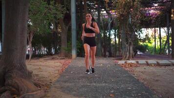 un mujer corriendo en un camino mediante un parque video