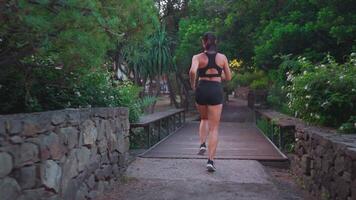 un mujer corriendo en un camino mediante un parque video