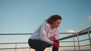 a woman is warming up on the bridge near the water video