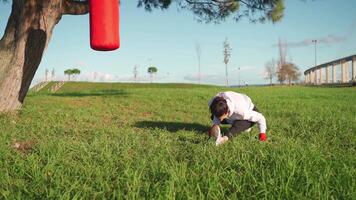 uma mulher praticando boxe com vermelho boxe saco dentro a parque video