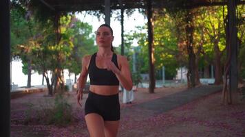 un mujer corriendo en un camino mediante un parque video