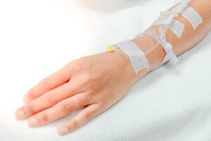 Soft focus, saline drip in patient's hand in hospital photo