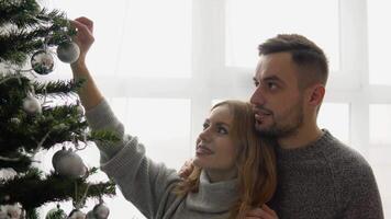 Couple decorating the Christmas tree together in the Christmas Eve video