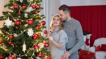 Couple decorating the Christmas tree together in the Christmas Eve video