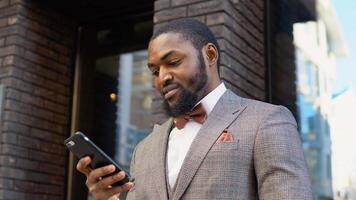 Elegant bearded african businessman talking on phone near the office center video