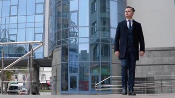 A businessman in a suit walking through the business center. Slow motion video