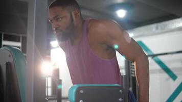 barbu noir homme faire des exercices dans le salle de sport. la musculation concept video